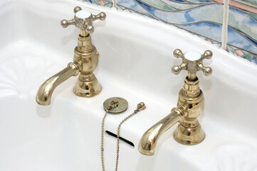 New luxury hotel vintage brass gold plated pillar taps in ensuite bathroom at wash basin