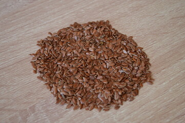 flaxseed on a wooden background. flax is very healthy as an addition to the diet because it lowers cholesterol and cleanses blood vessels.