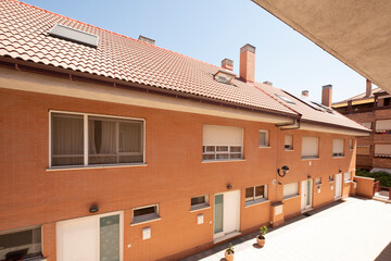 Facades of single-family homes with an interior corridor one day in full sun