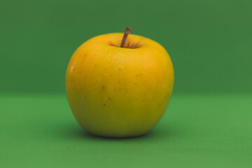 Close up view of an apple against green background