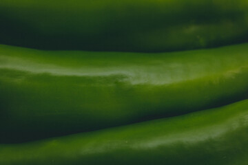 close up view of green peppers texture - dark green background
