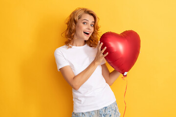 amazed happy redhead girl with love heart balloon. charity and donation