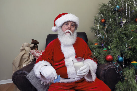 Santa Claus feeling sick after eating cookies and drinking milk left out on Christmas Eve