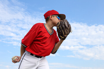 Boy pitcher getting ready to pitch the ball in a baseball game