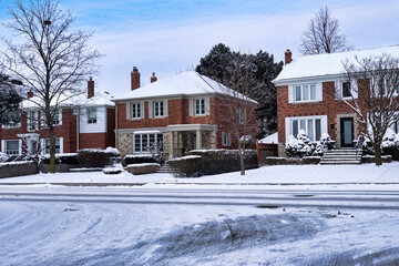 Street of traditional two story houses covered in snow