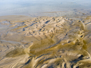 Sand texture after an heavy storm with beautiful sand sculptures on the edge of the pond after a...