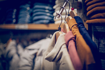 Sweaters on hangers. Shopping in store. Clothes on hangers in shop for sale