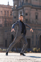Vertical photo of a man in a suit dancing flamenco outdoors