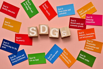 Among the scattered cards with the 17 goals of the Sustainable Development Goals, there is a cube lined up with the letters of the SDGs.