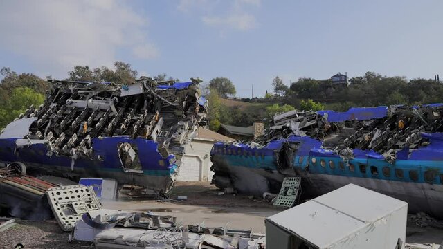 This panning video shows a crashed 747 airplane on an outdoor suburban neighborhood disaster scene.
