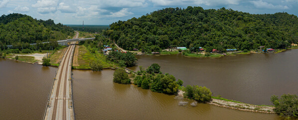 Fototapeta na wymiar Aerial panoramic drone view of railway track across a lake in Bukit Merah, Simpang Empat Semanggol, Perak, Malaysia.