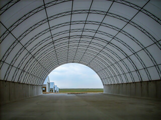 Frame and metal arches of a fabric covered hoop barn under construction.