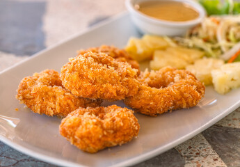 Deep-fried Shrimp cake, close up Thai food Deep-fried shrimp cake in white plate on a stone table with plum sauce. Crispy Deep-fried Shrimp cake