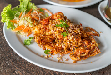 Close up Thai food image, deep-fried soft shell crab with garlic on wooden table, crispy deep-fried soft shell crab with garlic. 45-degree angle view.