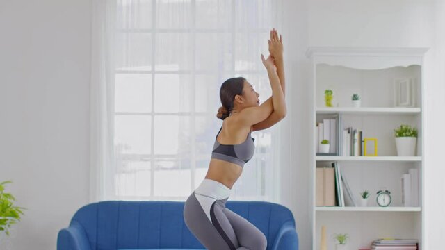 Calm of Attractive Asian woman practice yoga Eagle or Garudasana pose to stretching and meditation at home Feeling so comfortable and relax,Wellness Healthcare Concept