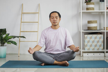 Handsome young asian man meditation at home
