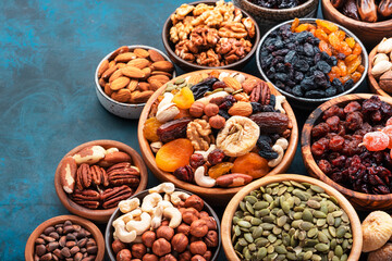 Nuts and dried fruits in assortment. Dry apricots, figs, raisins, walnuts, almonds and other. Blue table background, top view, copy space