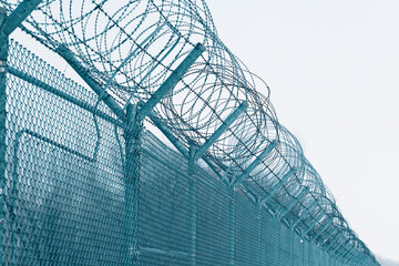 Barbed wire. Security measures for prisoners in prison. Prison fence against blue sky. 