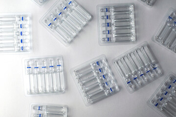 plastic transparent containers with glass ampoules on a white background