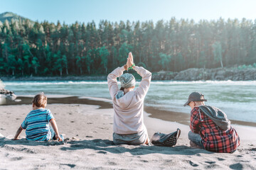mother and sons on the beach of river