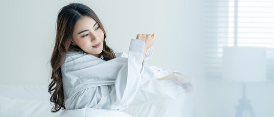 Asian beautiful girl in pajamas wake up in the morning with happiness.