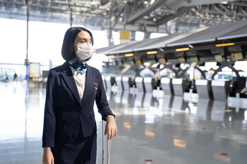 Airliner air hostess crew wearing face mask, walk in airport terminal. 
