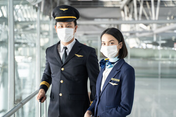 Portrait of Asian airliner pilot and air hostess wear mask and smile.  - obrazy, fototapety, plakaty
