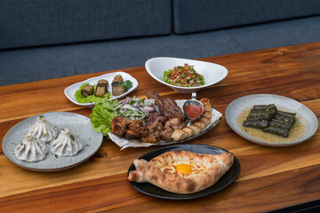 Festive feast with different dishes from Georgia, Armenia and Russia. Caucasian cuisine. Various delicious dishes on the wooden table. 