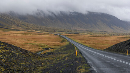 Scenic road through Snæfellsjokull National Park and Snæfellsjokull peak with cloud cover - obrazy, fototapety, plakaty