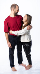 dad hugs daughter by the shoulders in the studio. a man in a burgundy-red T-shirt, a girl in a white sweatshirt. isolated white background