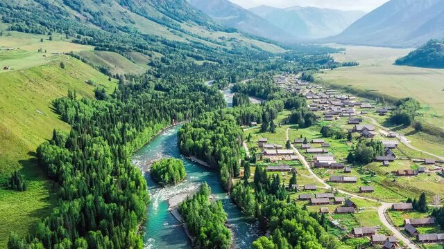 Aerial footage of Kanas Hemu Village buildings and green natural landscape in Xinjiang, China. Hemu Village is in the beautiful valley.