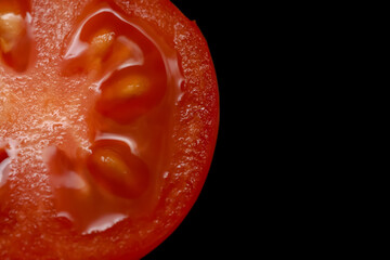 Cut section of cherry tomato on black background