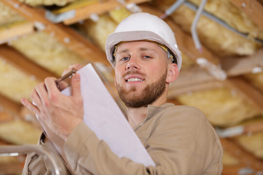 low angle portrait of young builder holding clipboard