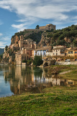 Miravet village and its Templar castle on top of the hill on the banks of the Ebro river, Tarragona, Spain - obrazy, fototapety, plakaty