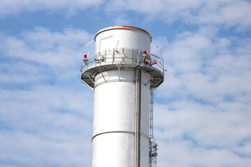 Industrial view of small silver color electric plant chimney.