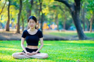 Asian woman wearing a black dress Meditation in the park