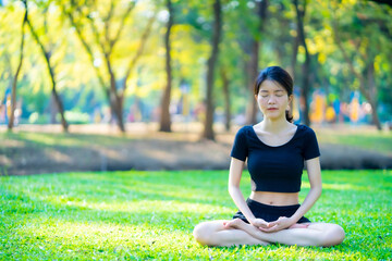 Asian woman wearing a black dress Meditation in the park