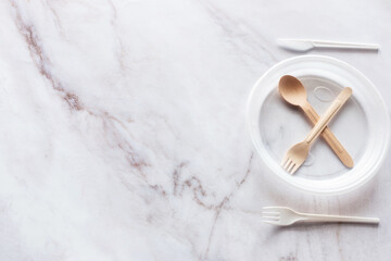 Obraz na płótnie Canvas plastic plate with a cross made of wooden cutlery. ban on plastic dishes with place for text