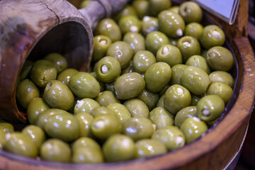 Stuffed green olives in an old wooden bowl