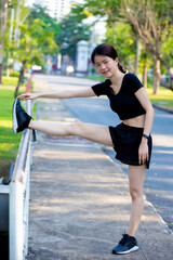 Asian woman wearing a black dress warm-up before Jogging in the park