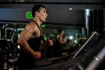 Fototapeta na wymiar Asian men wear black workout in fitness center