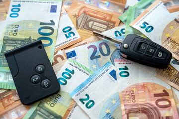 black auto key on pile of euro bills, mortgage or payment