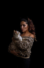 Adorable woman holding a bengal cat in her arms and depicts a kiss isolated