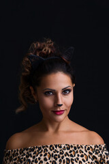 Seductive girl with cat makeup and ears seduces with a look on black background