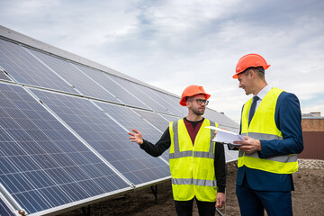 tall men in work clothes are considering whether to install solar panels in the open air.