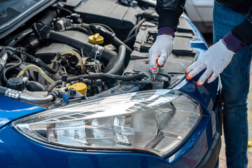 Male hands with a wrench  repair to engine in the open hood of the car