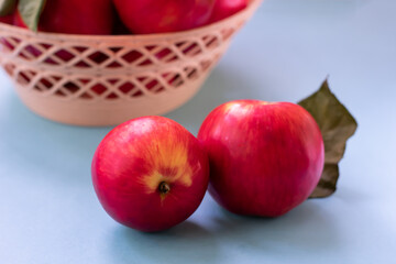Ripe mature homegrown red apples on blue background. Close up vegetarian organic food