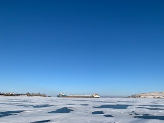 Obraz premium a view of the ships in the winter anchorage on the Volga River in ice and covered with snow