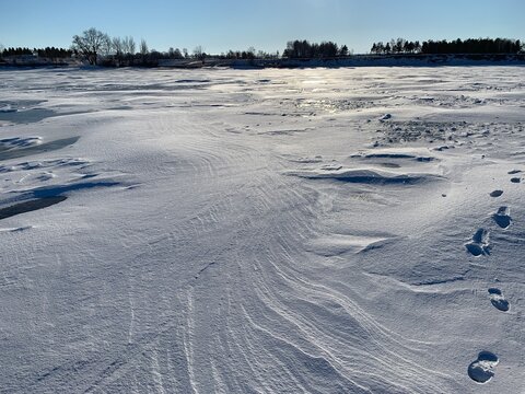 white snow drifts from the wind on the ice of the Volga River