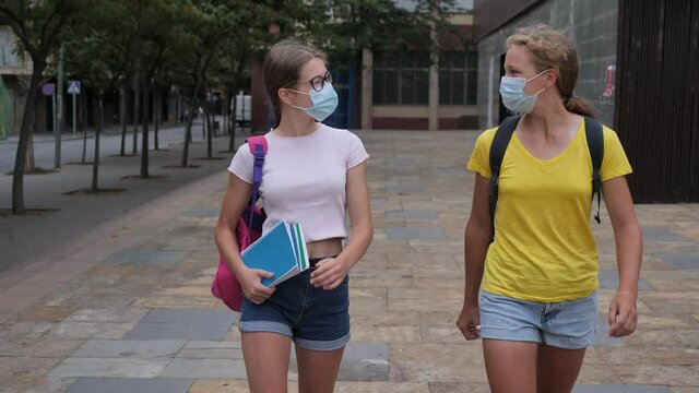 Girl student in protective mask walks down the street to college. High quality 4k footage